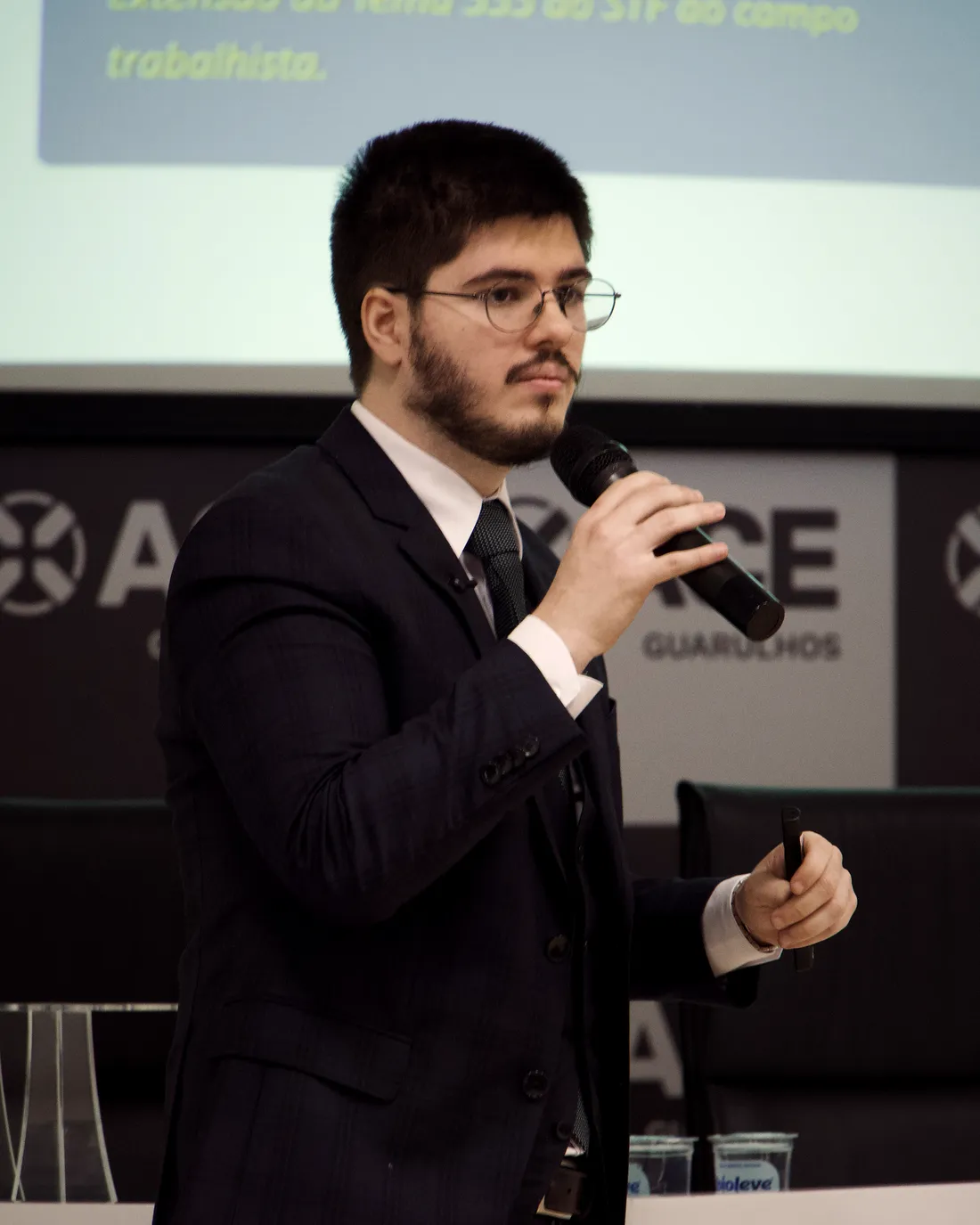 Arthur Galante da Cunha falando ao microfone em palestra para empresários